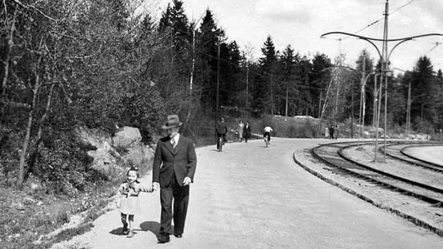 1939 Råsundavägen (dåvarande Stockholmsvägen) vid Näckrosen. Axel Skoglund promenerar med sonen Ingemar mot Sundbyberg.